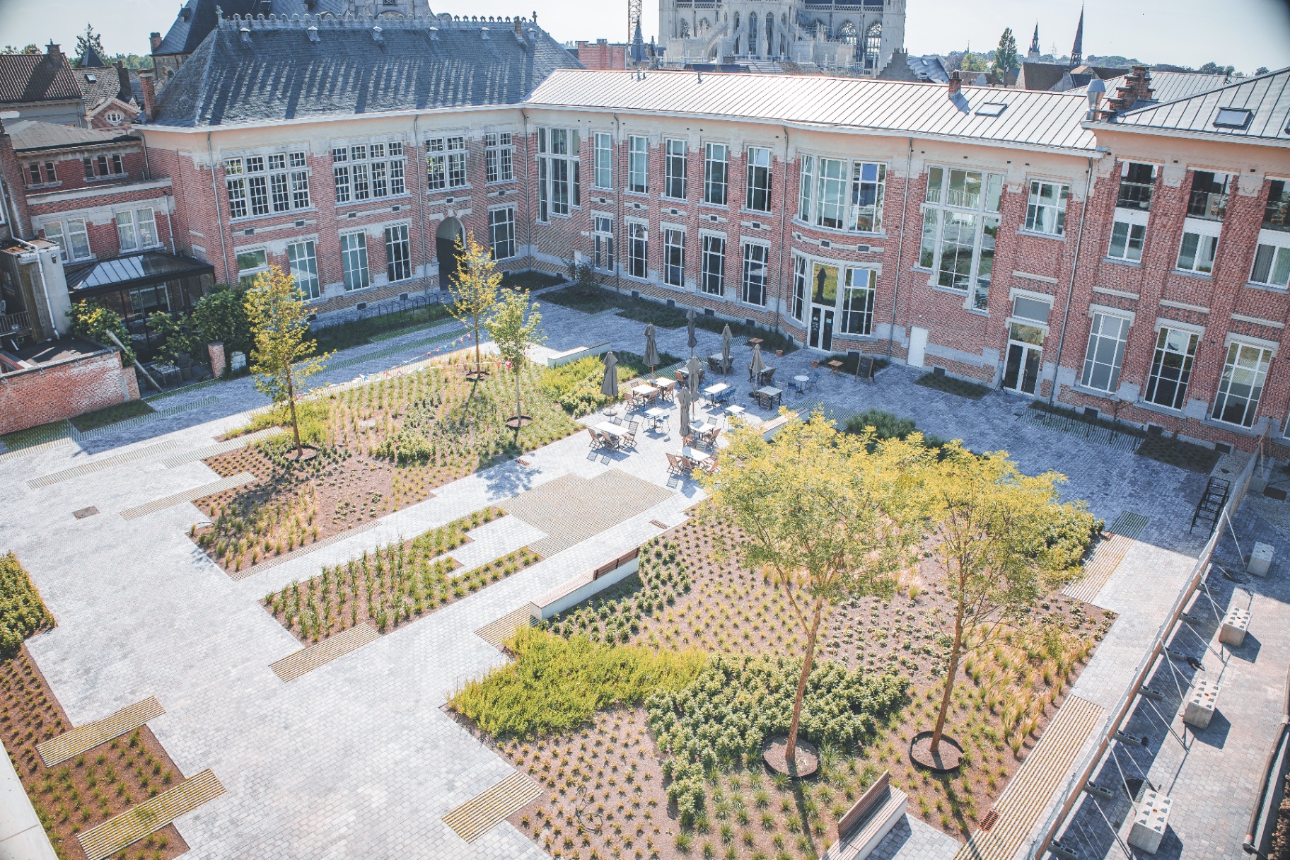 Luchtfoto van de binnentuin met historisch gebouw en Sint-Gummaruskerk