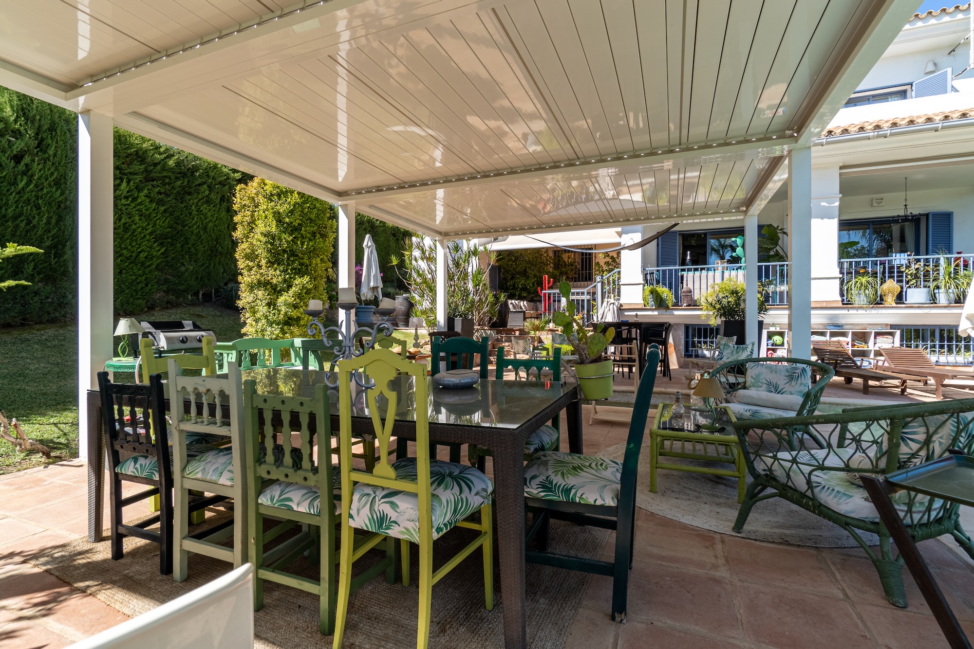 Espace ext&eacute;rieur avec coin salon au bord de la piscine