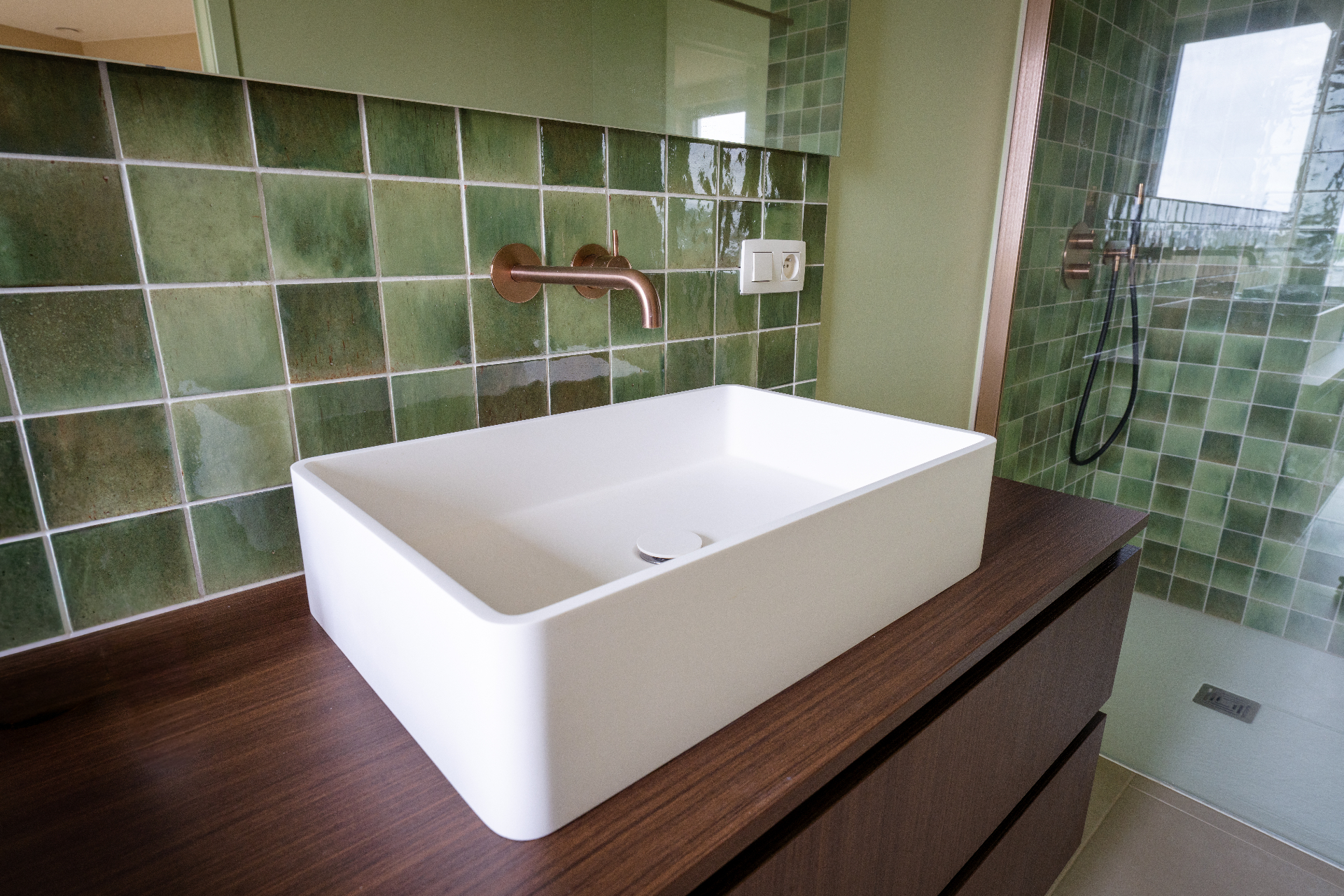 Groene badkamer met wastafel en inloopdouche