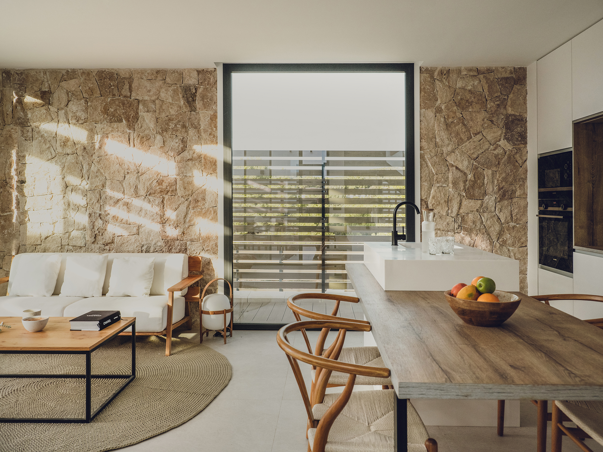 Woonkamer met natuursteen wand en open keuken