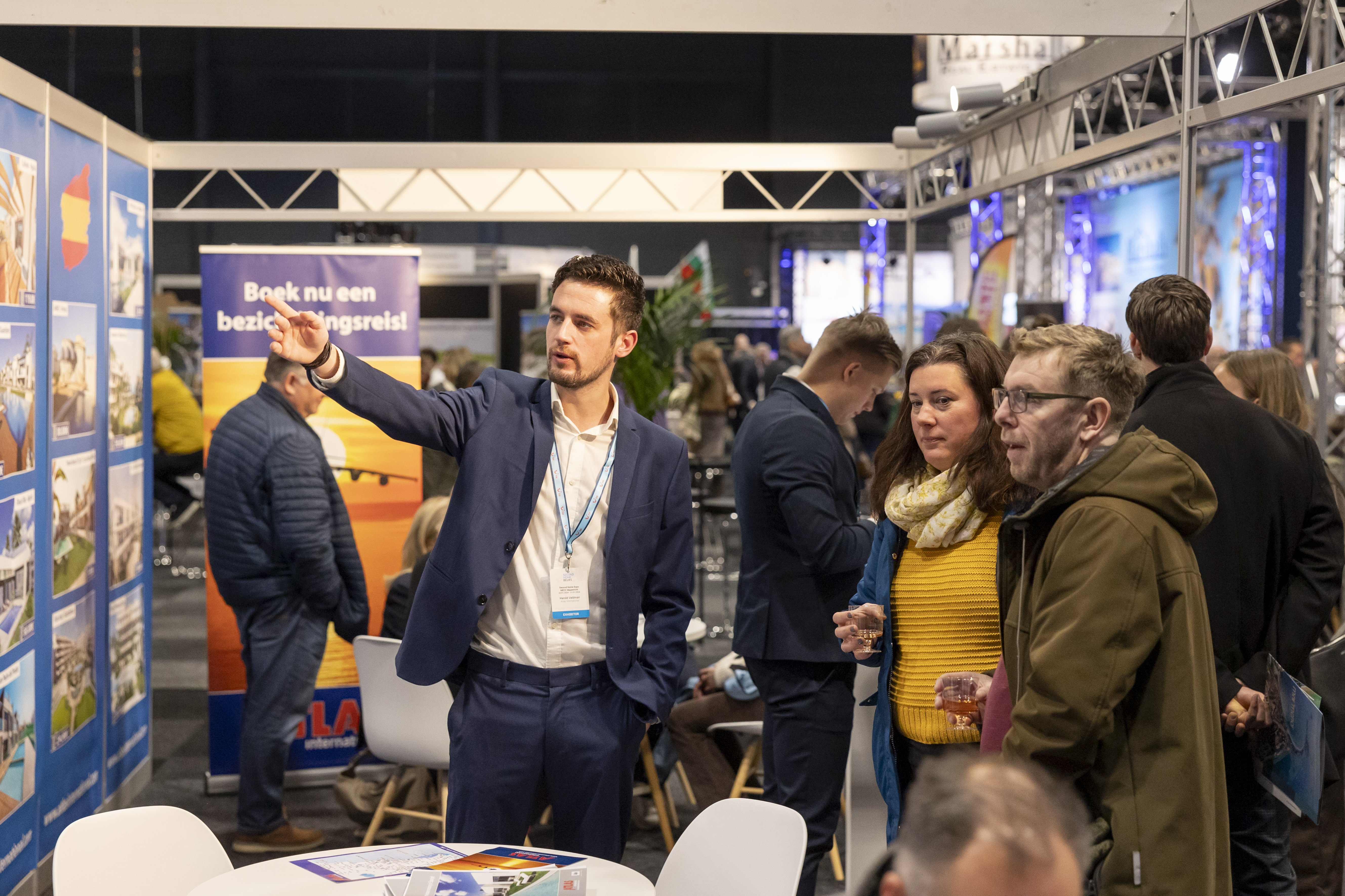 Adviseur in gesprek met bezoekers op de beurs