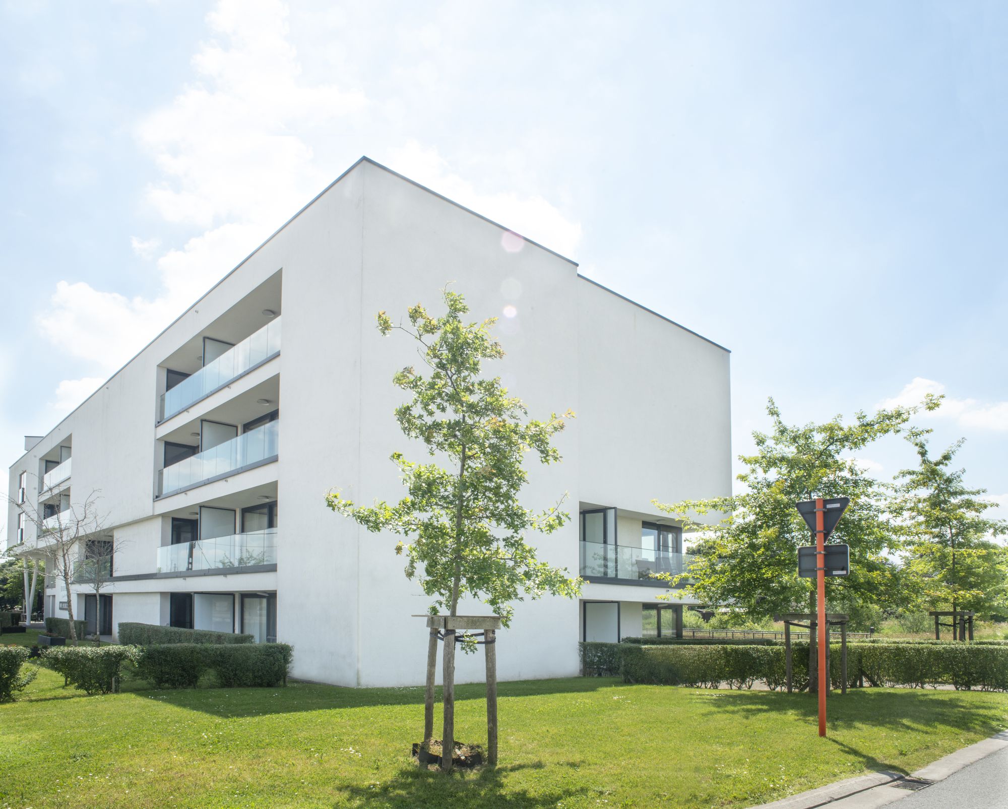 Het witte gebouw van Residentie Vijverhof met glazen balkons