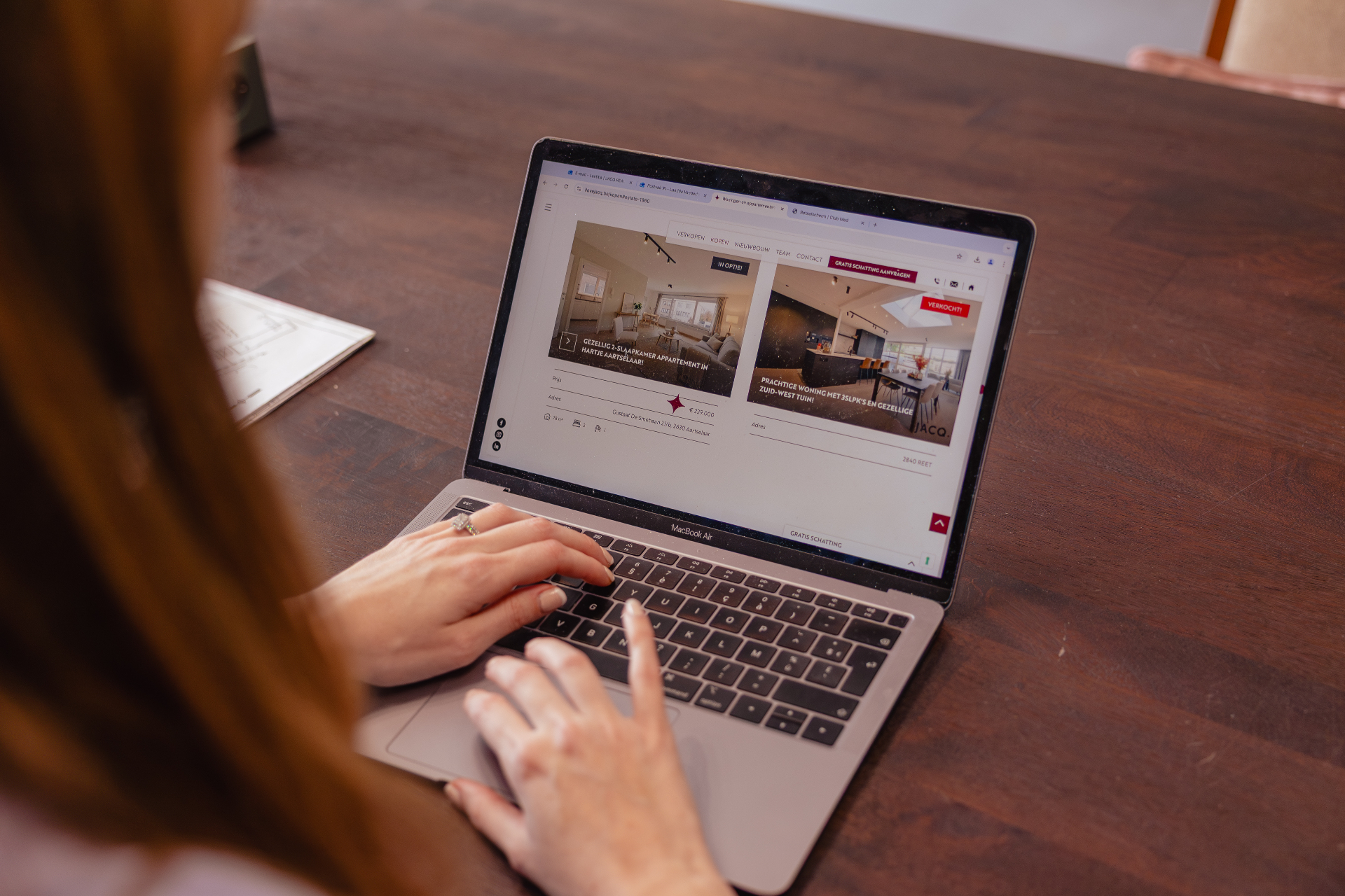 JACQ-medewerkster bekijkt vastgoedaanbod op de laptop in het kantoor